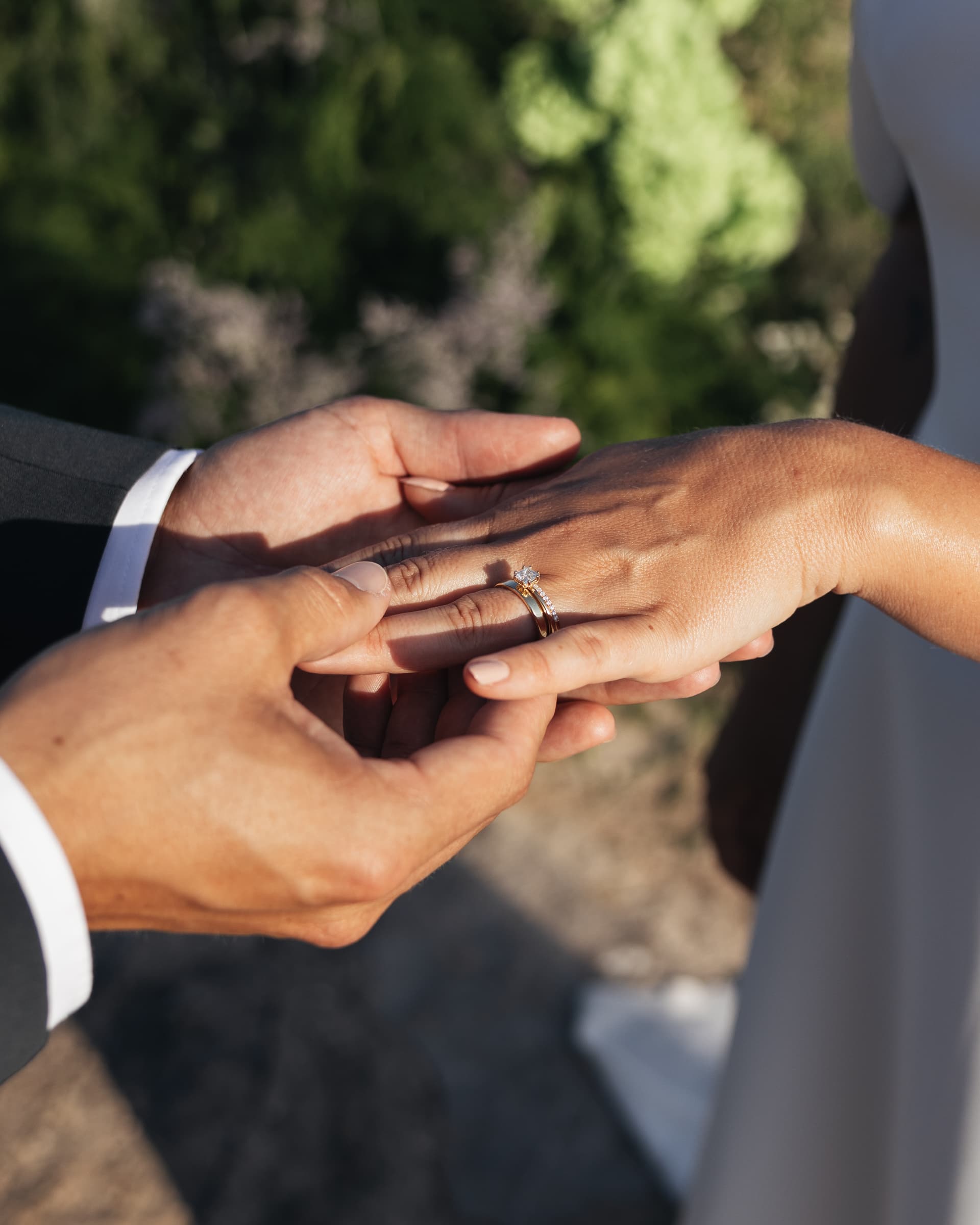 Close view of two people holding hands outdoors.