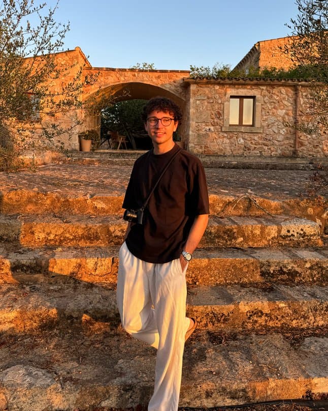 Portrait of photographer Niklas Frech standing on stone steps.